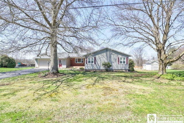 ranch-style home featuring a front lawn, driveway, and a garage