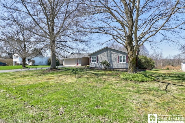 single story home featuring an attached garage, driveway, and a front lawn