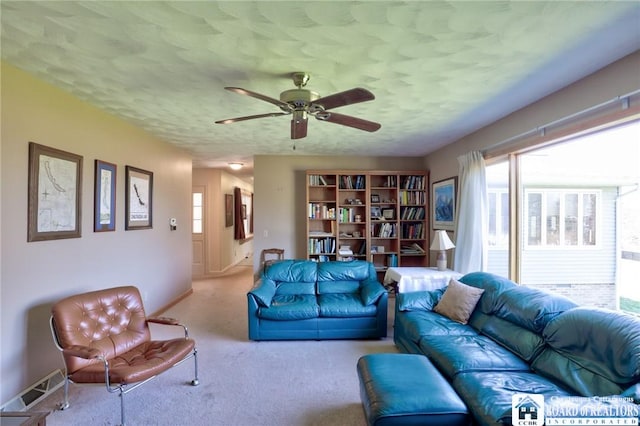 carpeted living area featuring a ceiling fan, a textured ceiling, visible vents, and a healthy amount of sunlight
