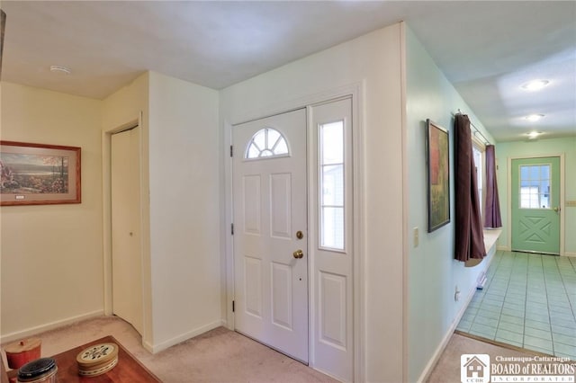 foyer entrance with light carpet and baseboards