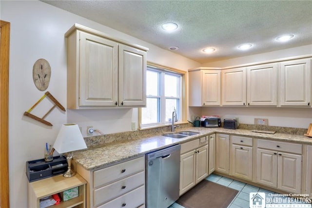 kitchen with light stone counters, dishwasher, light tile patterned floors, a sink, and a textured ceiling
