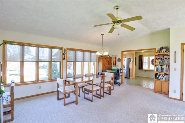 dining area with a wealth of natural light, a textured ceiling, and light colored carpet