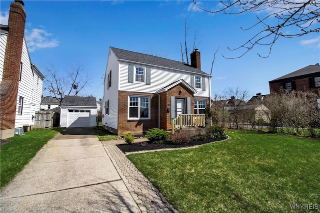 view of front of home with a chimney, a front lawn, driveway, an outbuilding, and brick siding