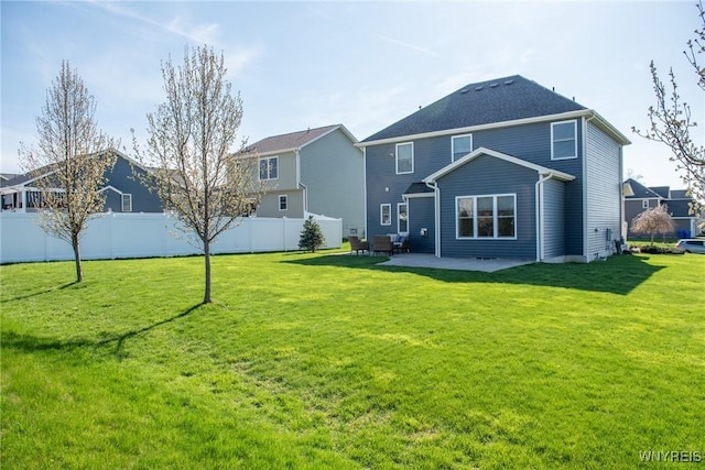 back of property with a yard, a patio, and fence