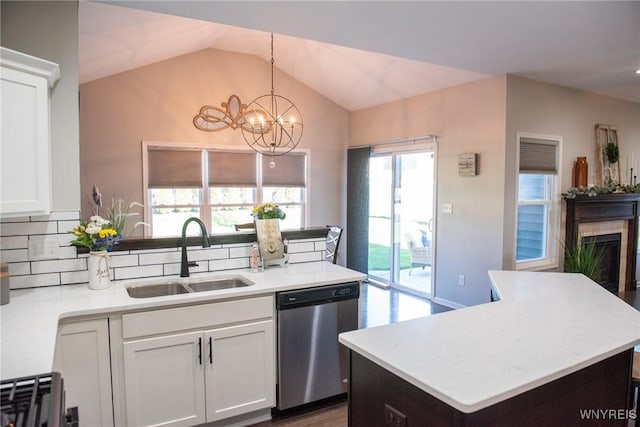 kitchen featuring stainless steel dishwasher, a sink, a notable chandelier, white cabinetry, and light countertops