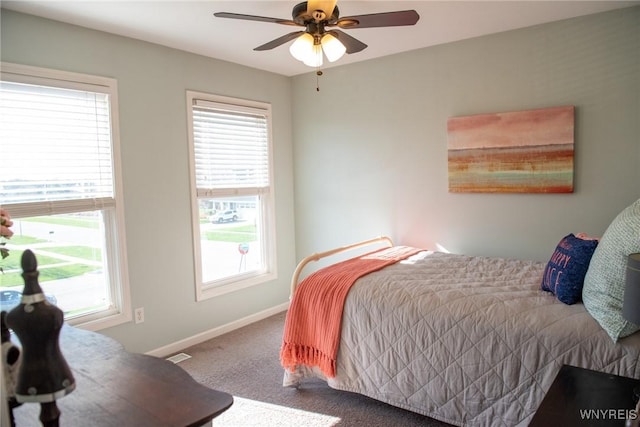 carpeted bedroom with visible vents, a ceiling fan, and baseboards