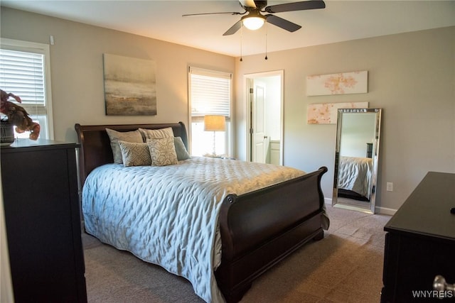 bedroom with carpet, a ceiling fan, multiple windows, and ensuite bathroom