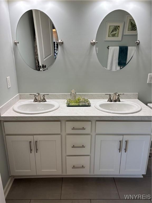 full bathroom with tile patterned floors, a sink, and double vanity