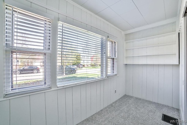 35 University Ct, Amherst, NY 14226 - spare room featuring wooden walls, visible vents, carpet flooring, and crown molding