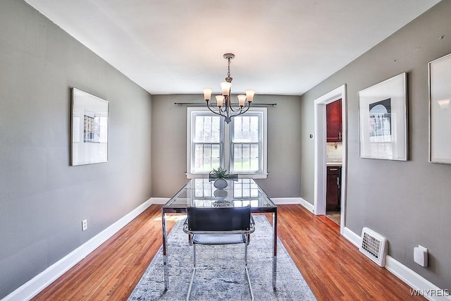35 University Ct, Amherst, NY 14226 - dining space featuring baseboards, wood finished floors, a chandelier, and visible vents