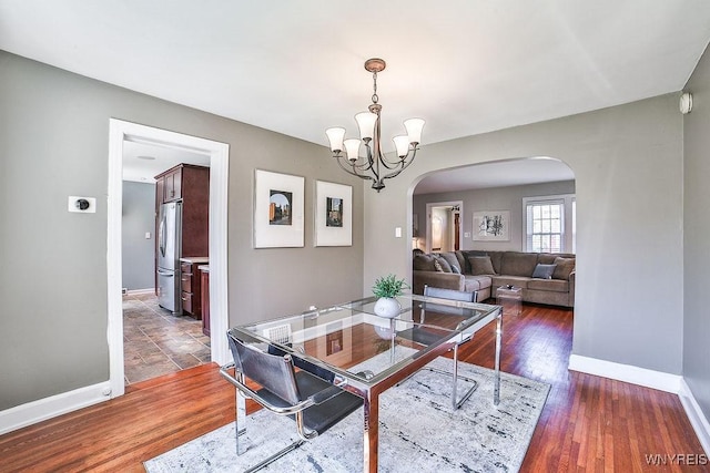 35 University Ct, Amherst, NY 14226 - dining space with arched walkways, wood finished floors, baseboards, and an inviting chandelier