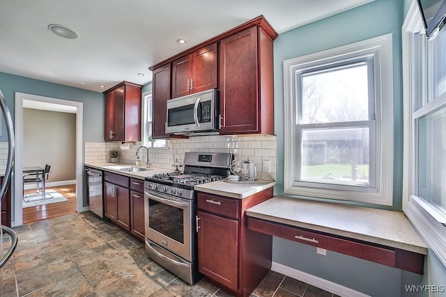 35 University Ct, Amherst, NY 14226 - kitchen featuring decorative backsplash, stainless steel appliances, a sink, and a healthy amount of sunlight