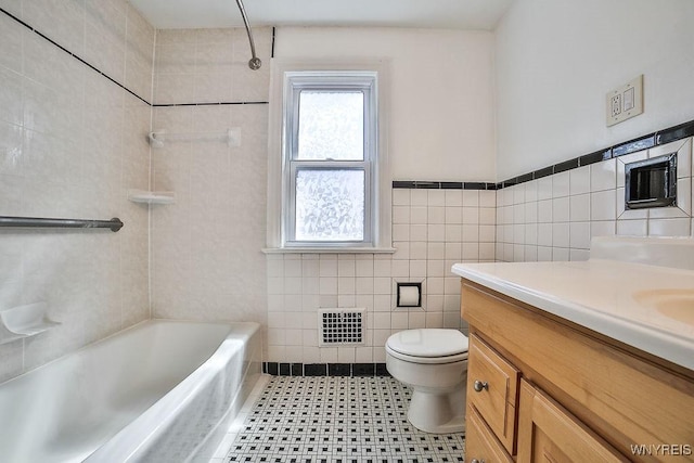35 University Ct, Amherst, NY 14226 - bathroom featuring a wainscoted wall, visible vents, toilet, vanity, and tile walls