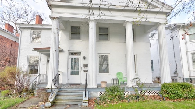 neoclassical home featuring brick siding