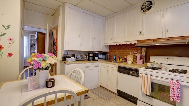 kitchen featuring white appliances, light countertops, white cabinets, backsplash, and under cabinet range hood
