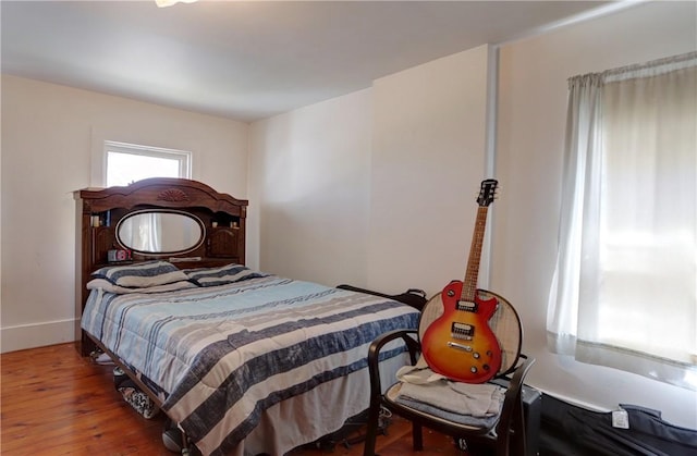 bedroom featuring hardwood / wood-style flooring and baseboards