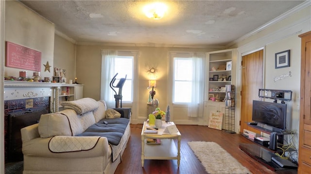 living area with crown molding, wood finished floors, a textured ceiling, and a healthy amount of sunlight