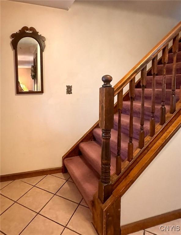 stairs featuring tile patterned floors and baseboards