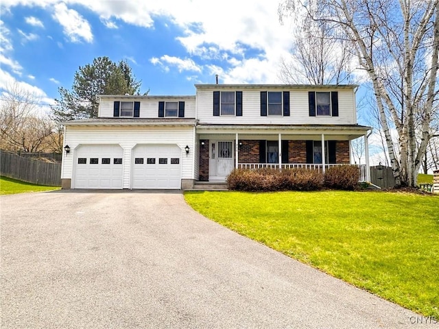 traditional home featuring a front lawn, driveway, covered porch, an attached garage, and fence