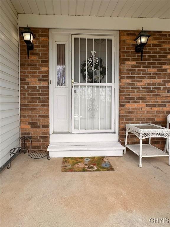 property entrance with brick siding and covered porch