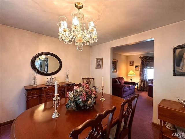 carpeted dining area with a chandelier