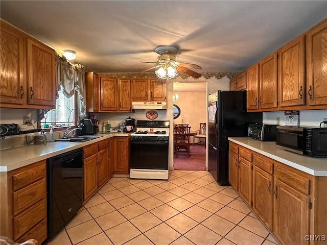 kitchen featuring a sink, brown cabinets, ceiling fan, under cabinet range hood, and black appliances