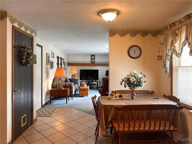 dining room with light colored carpet and light tile patterned flooring