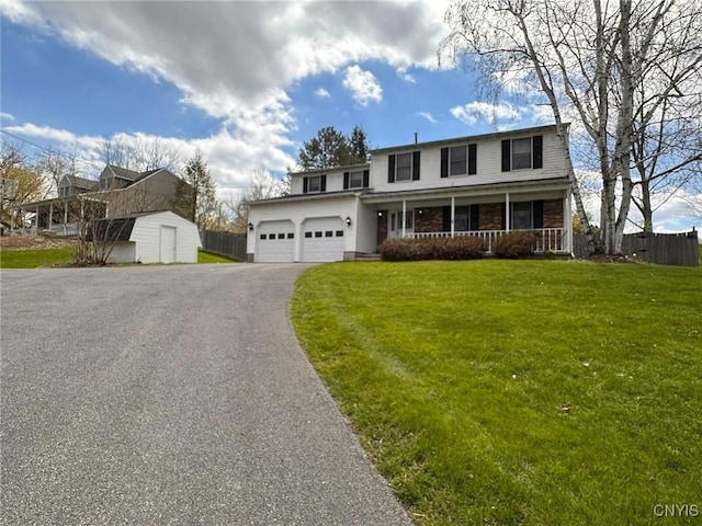 view of front of property featuring covered porch, fence, a shed, a front yard, and aphalt driveway