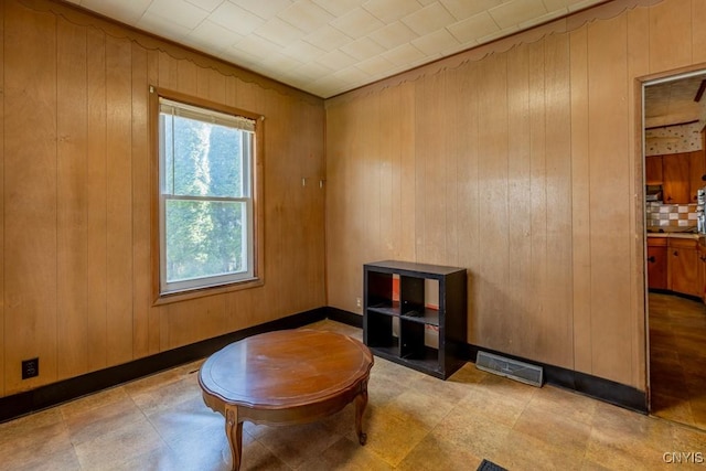 sitting room featuring wooden walls and visible vents