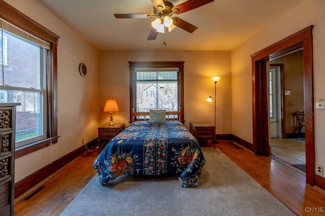 bedroom featuring hardwood / wood-style flooring, baseboards, and multiple windows