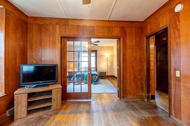 entryway with a ceiling fan, french doors, hardwood / wood-style floors, and wooden walls