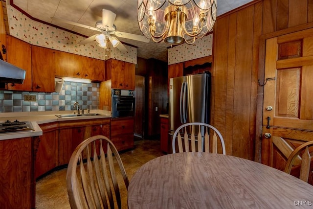 kitchen featuring backsplash, brown cabinetry, stainless steel appliances, and a sink