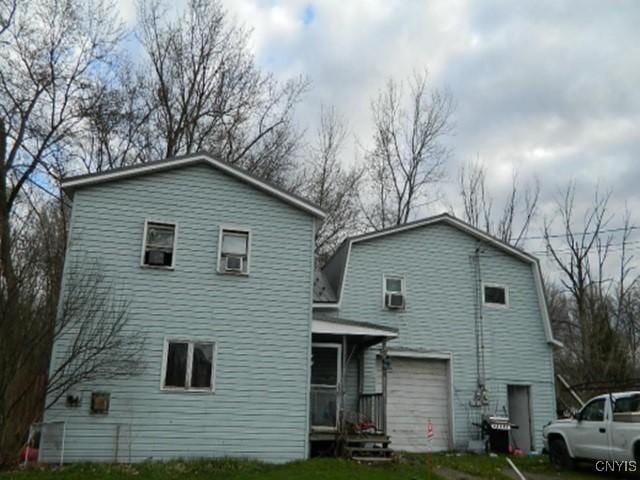 16 W 10th St Unit E, Jamestown, NY 14701 - back of house featuring a garage and a lawn