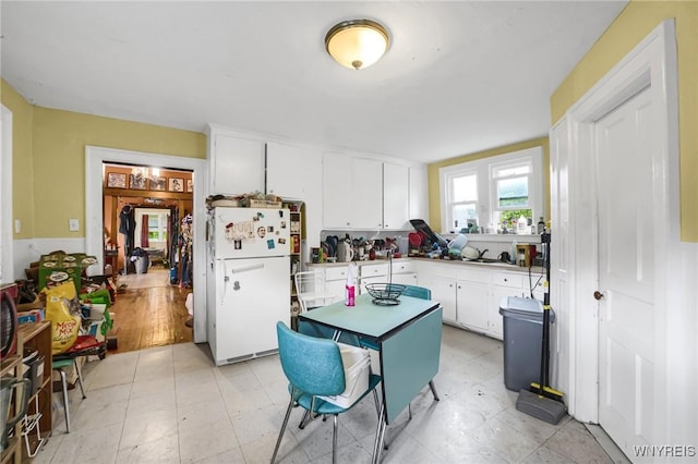348 Virginia St, Buffalo, NY 14201 - kitchen featuring light floors, white cabinets, and freestanding refrigerator