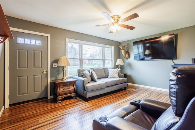 living room with baseboards, a ceiling fan, and wood finished floors