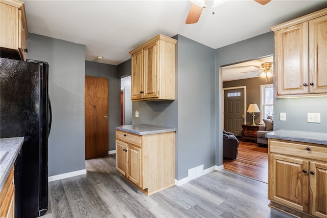 kitchen with light brown cabinets, freestanding refrigerator, dark wood-type flooring, and ceiling fan