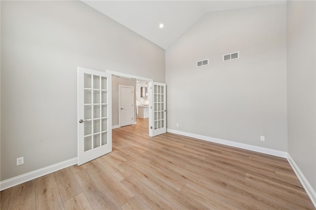 2 Stella Ln, Ogden, NY 14559 - empty room featuring french doors, high vaulted ceiling, and light wood-type flooring