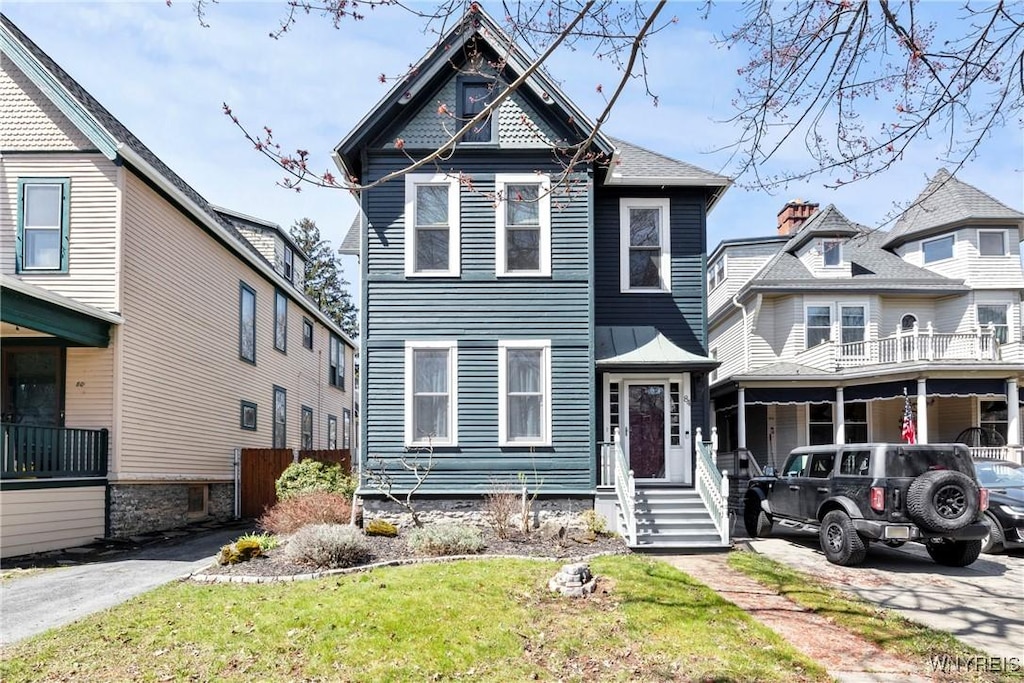 victorian house featuring a front lawn
