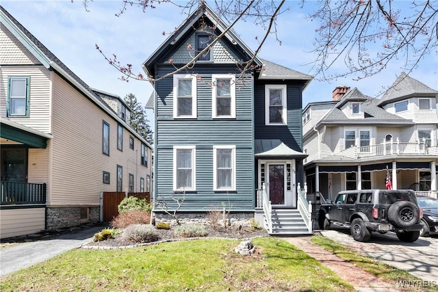 victorian house featuring a front lawn