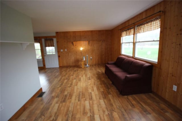living area featuring wood finished floors, a wealth of natural light, and wood walls