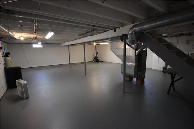 basement featuring stairs and heating unit