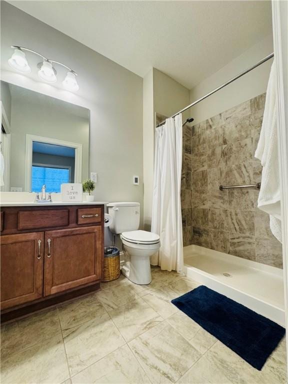 full bath with toilet, vanity, and tiled shower