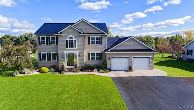colonial house with a front lawn, driveway, metal roof, and a garage