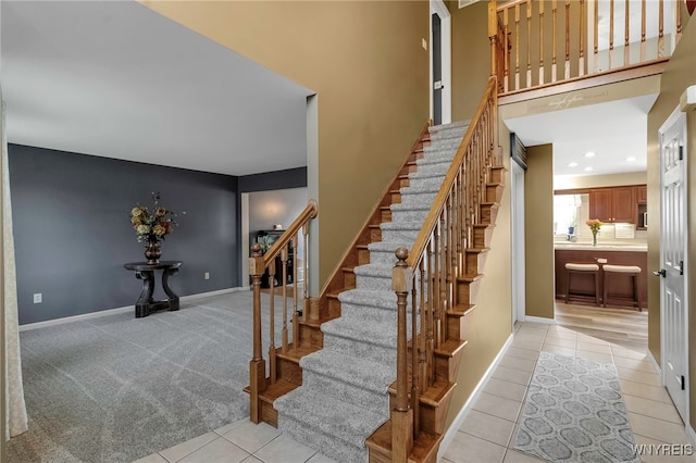 staircase with baseboards and tile patterned flooring