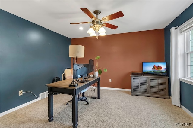 carpeted office featuring a ceiling fan and baseboards