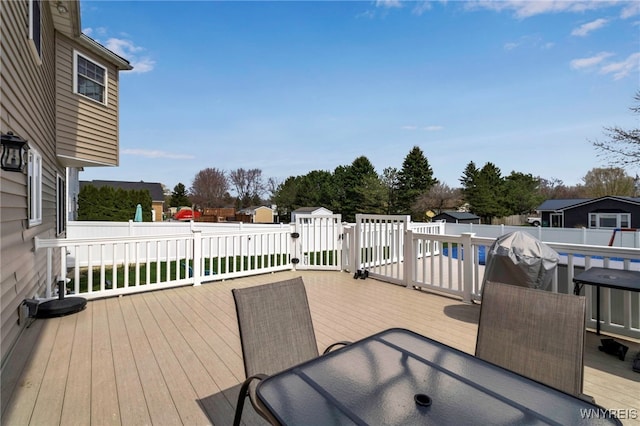 wooden terrace with a fenced backyard and a fenced in pool