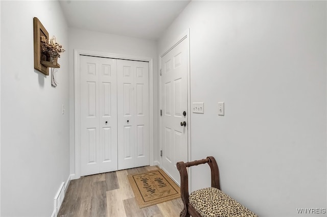 entryway with wood finished floors, visible vents, and baseboards