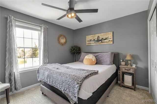 carpeted bedroom with a ceiling fan, baseboards, and a closet