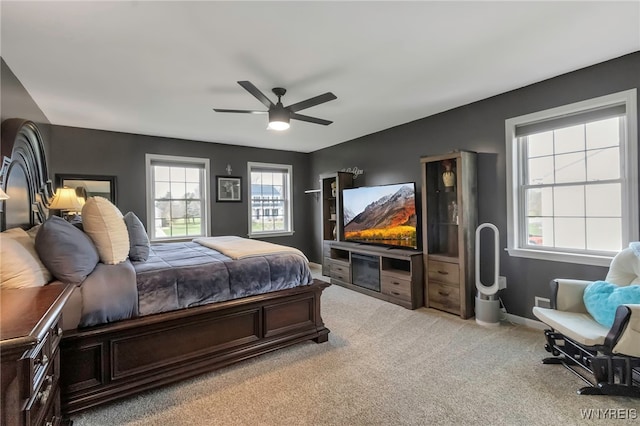 bedroom with light carpet, a ceiling fan, and baseboards