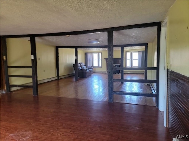 entrance foyer with a baseboard heating unit, wood finished floors, and a textured ceiling